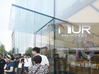 Customers line up outside the Apple flagship store as they wait to enter the store to buy the iPhone 16 in Hangzhou, China, on September 20,...