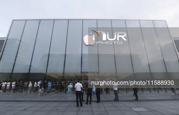 Customers line up outside the Apple flagship store as they wait to enter the store to buy the iPhone 16 in Hangzhou, China, on September 20,...