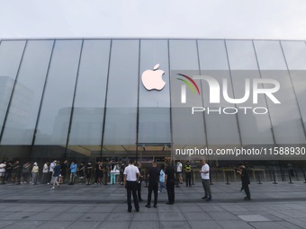 Customers line up outside the Apple flagship store as they wait to enter the store to buy the iPhone 16 in Hangzhou, China, on September 20,...