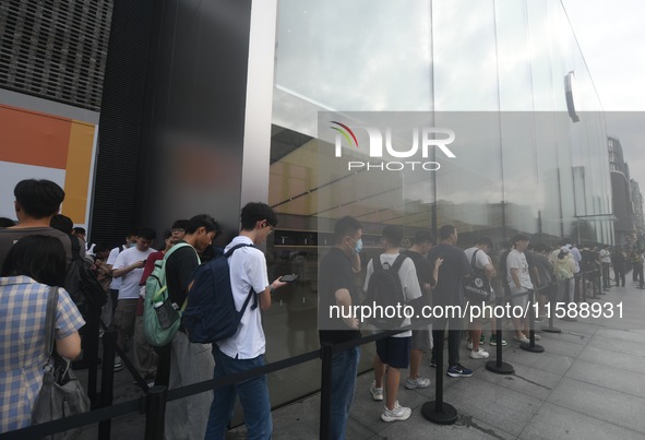 Customers line up outside the Apple flagship store as they wait to enter the store to buy the iPhone 16 in Hangzhou, China, on September 20,...