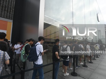 Customers line up outside the Apple flagship store as they wait to enter the store to buy the iPhone 16 in Hangzhou, China, on September 20,...