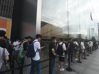 Customers line up outside the Apple flagship store as they wait to enter the store to buy the iPhone 16 in Hangzhou, China, on September 20,...