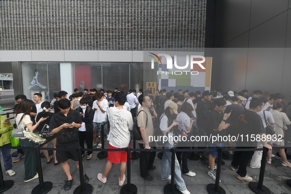 Customers line up outside the Apple flagship store as they wait to enter the store to buy the iPhone 16 in Hangzhou, China, on September 20,...