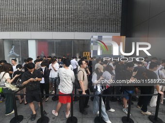 Customers line up outside the Apple flagship store as they wait to enter the store to buy the iPhone 16 in Hangzhou, China, on September 20,...