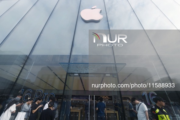 Customers line up outside the Apple flagship store as they wait to enter the store to buy the iPhone 16 in Hangzhou, China, on September 20,...