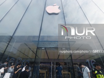 Customers line up outside the Apple flagship store as they wait to enter the store to buy the iPhone 16 in Hangzhou, China, on September 20,...