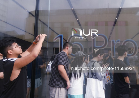 Customers line up outside the Apple flagship store as they wait to enter the store to buy the iPhone 16 in Hangzhou, China, on September 20,...