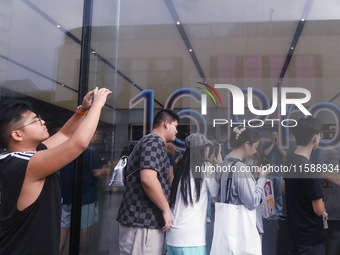 Customers line up outside the Apple flagship store as they wait to enter the store to buy the iPhone 16 in Hangzhou, China, on September 20,...