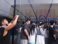 Customers line up outside the Apple flagship store as they wait to enter the store to buy the iPhone 16 in Hangzhou, China, on September 20,...