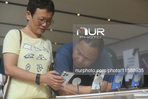 Customers experience an iPhone 16 at the Apple flagship store in Hangzhou, China, on September 20, 2024. 