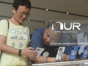 Customers experience an iPhone 16 at the Apple flagship store in Hangzhou, China, on September 20, 2024. (