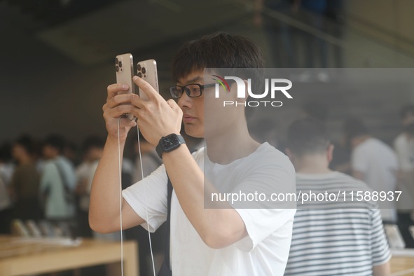 Customers experience an iPhone 16 at the Apple flagship store in Hangzhou, China, on September 20, 2024. 