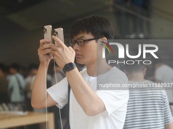 Customers experience an iPhone 16 at the Apple flagship store in Hangzhou, China, on September 20, 2024. (