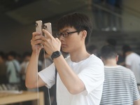 Customers experience an iPhone 16 at the Apple flagship store in Hangzhou, China, on September 20, 2024. (