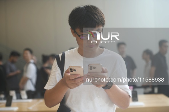 Customers experience an iPhone 16 at the Apple flagship store in Hangzhou, China, on September 20, 2024. 