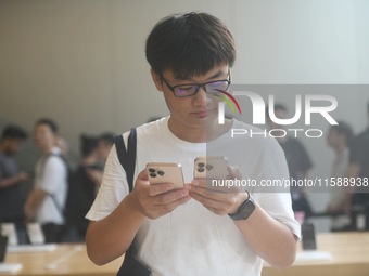 Customers experience an iPhone 16 at the Apple flagship store in Hangzhou, China, on September 20, 2024. (