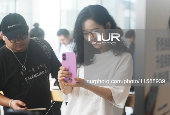 Customers experience an iPhone 16 at the Apple flagship store in Hangzhou, China, on September 20, 2024. 