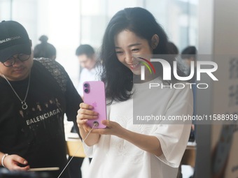 Customers experience an iPhone 16 at the Apple flagship store in Hangzhou, China, on September 20, 2024. (