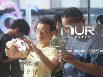 Customers experience an iPhone 16 at the Apple flagship store in Hangzhou, China, on September 20, 2024. (