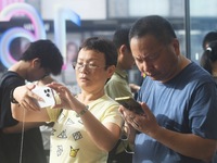 Customers experience an iPhone 16 at the Apple flagship store in Hangzhou, China, on September 20, 2024. (