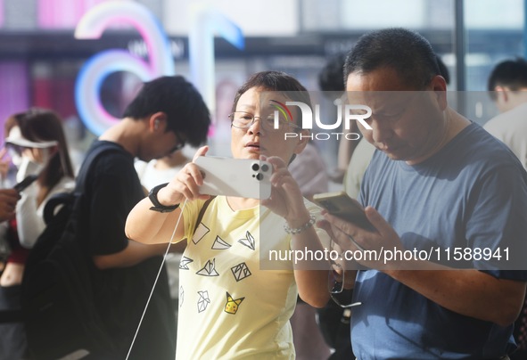 Customers experience an iPhone 16 at the Apple flagship store in Hangzhou, China, on September 20, 2024. 