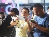 Customers experience an iPhone 16 at the Apple flagship store in Hangzhou, China, on September 20, 2024. (