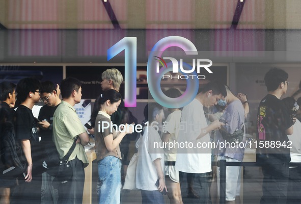 Customers line up outside the Apple flagship store as they wait to enter the store to buy the iPhone 16 in Hangzhou, China, on September 20,...