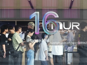 Customers line up outside the Apple flagship store as they wait to enter the store to buy the iPhone 16 in Hangzhou, China, on September 20,...