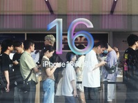 Customers line up outside the Apple flagship store as they wait to enter the store to buy the iPhone 16 in Hangzhou, China, on September 20,...