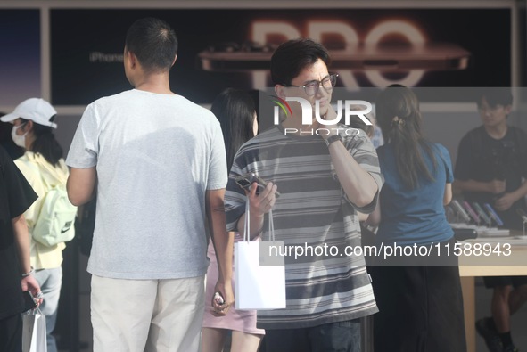 A customer walks out of Apple's Hangzhou flagship store after buying an iPhone 16 in Hangzhou, China, on September 20, 2024. 