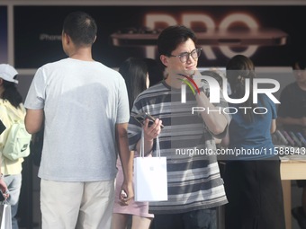 A customer walks out of Apple's Hangzhou flagship store after buying an iPhone 16 in Hangzhou, China, on September 20, 2024. (