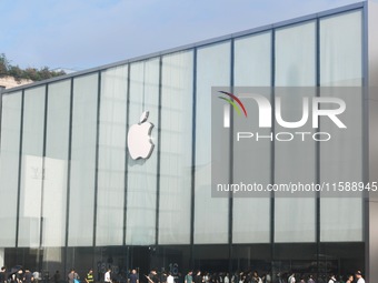 Customers line up outside the Apple flagship store as they wait to enter the store to buy the iPhone 16 in Hangzhou, China, on September 20,...