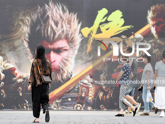 People walk past a poster promoting the Chinese 3A game Black Myth: Wukong in Renhuai, China, on September 15, 2024. (