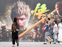 People walk past a poster promoting the Chinese 3A game Black Myth: Wukong in Renhuai, China, on September 15, 2024. (