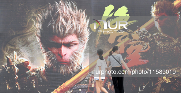 People walk past a poster promoting the Chinese 3A game Black Myth: Wukong in Renhuai, China, on September 15, 2024. 