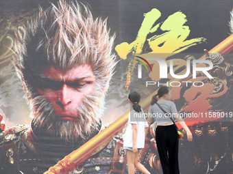 People walk past a poster promoting the Chinese 3A game Black Myth: Wukong in Renhuai, China, on September 15, 2024. (