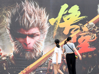 People walk past a poster promoting the Chinese 3A game Black Myth: Wukong in Renhuai, China, on September 15, 2024. (