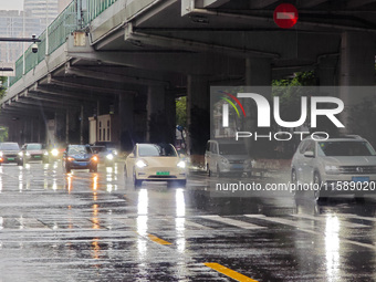 Pedestrians and vehicles brave the rain under the elevated Zhongshan South Road in Huangpu district in Shanghai, China, on September 20, 202...