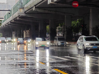 Pedestrians and vehicles brave the rain under the elevated Zhongshan South Road in Huangpu district in Shanghai, China, on September 20, 202...