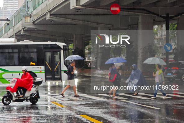 Pedestrians and vehicles brave the rain under the elevated Zhongshan South Road in Huangpu district in Shanghai, China, on September 20, 202...