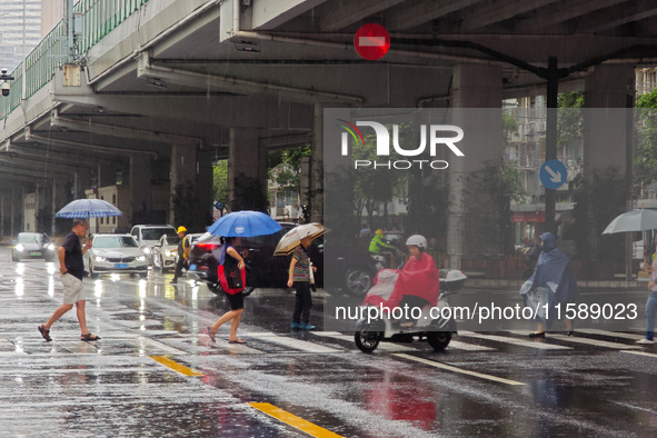 Pedestrians and vehicles brave the rain under the elevated Zhongshan South Road in Huangpu district in Shanghai, China, on September 20, 202...