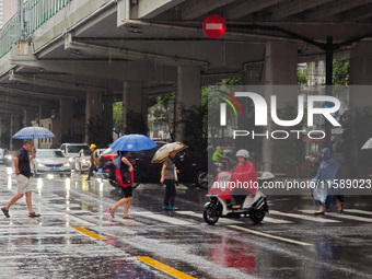 Pedestrians and vehicles brave the rain under the elevated Zhongshan South Road in Huangpu district in Shanghai, China, on September 20, 202...