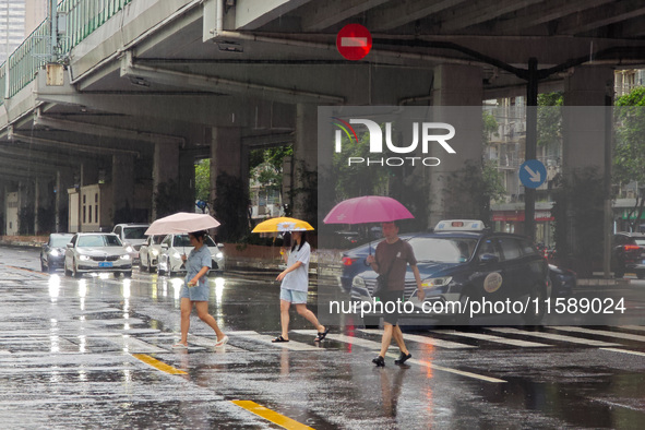 Pedestrians and vehicles brave the rain under the elevated Zhongshan South Road in Huangpu district in Shanghai, China, on September 20, 202...