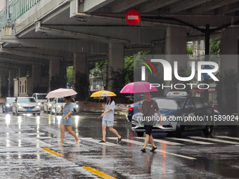 Pedestrians and vehicles brave the rain under the elevated Zhongshan South Road in Huangpu district in Shanghai, China, on September 20, 202...