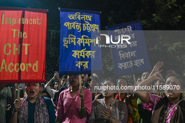 Protesters hold placards during the protest in Dhaka, Bangladesh, on September 19, 2024, against Bengali settler attacks on the Indigenous c...