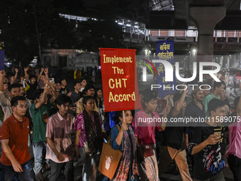 Protesters hold placards during the protest in Dhaka, Bangladesh, on September 19, 2024, against Bengali settler attacks on the Indigenous c...