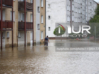 A man walks in the water between blocks after Nysa Klodzka river flooded town of Lewin Brzeski in southwestern Poland, on September 19th, 20...