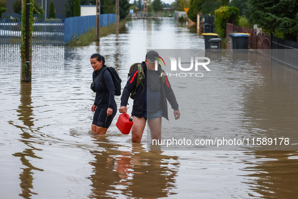 Residents walk in the water after Nysa Klodzka river flooded town of Lewin Brzeski in southwestern Poland, on September 19th, 2024. Storm Bo...