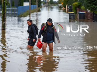 Residents walk in the water after Nysa Klodzka river flooded town of Lewin Brzeski in southwestern Poland, on September 19th, 2024. Storm Bo...