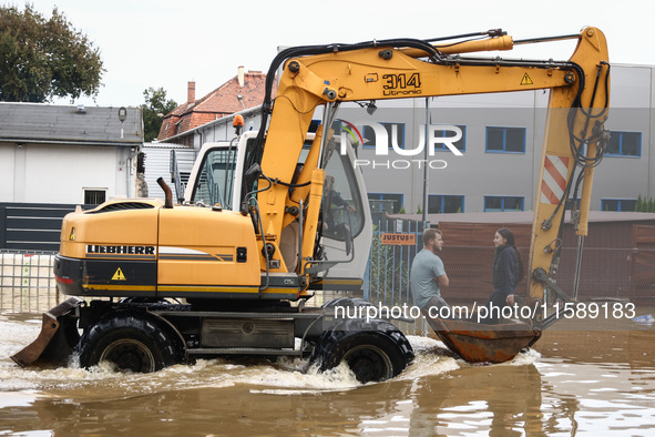 A couple rides on a digger after Nysa Klodzka river flooded town of Lewin Brzeski in southwestern Poland, on September 19th, 2024. Storm Bor...